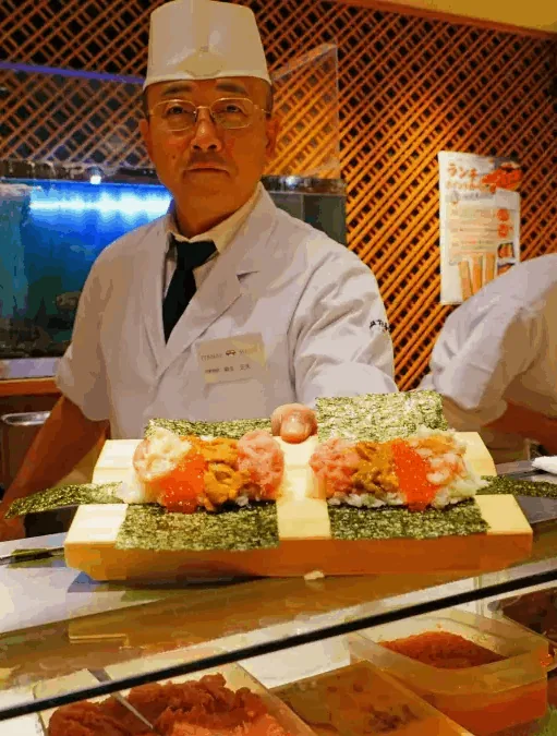 海苔巻きの盛り合わせを差し出す板前